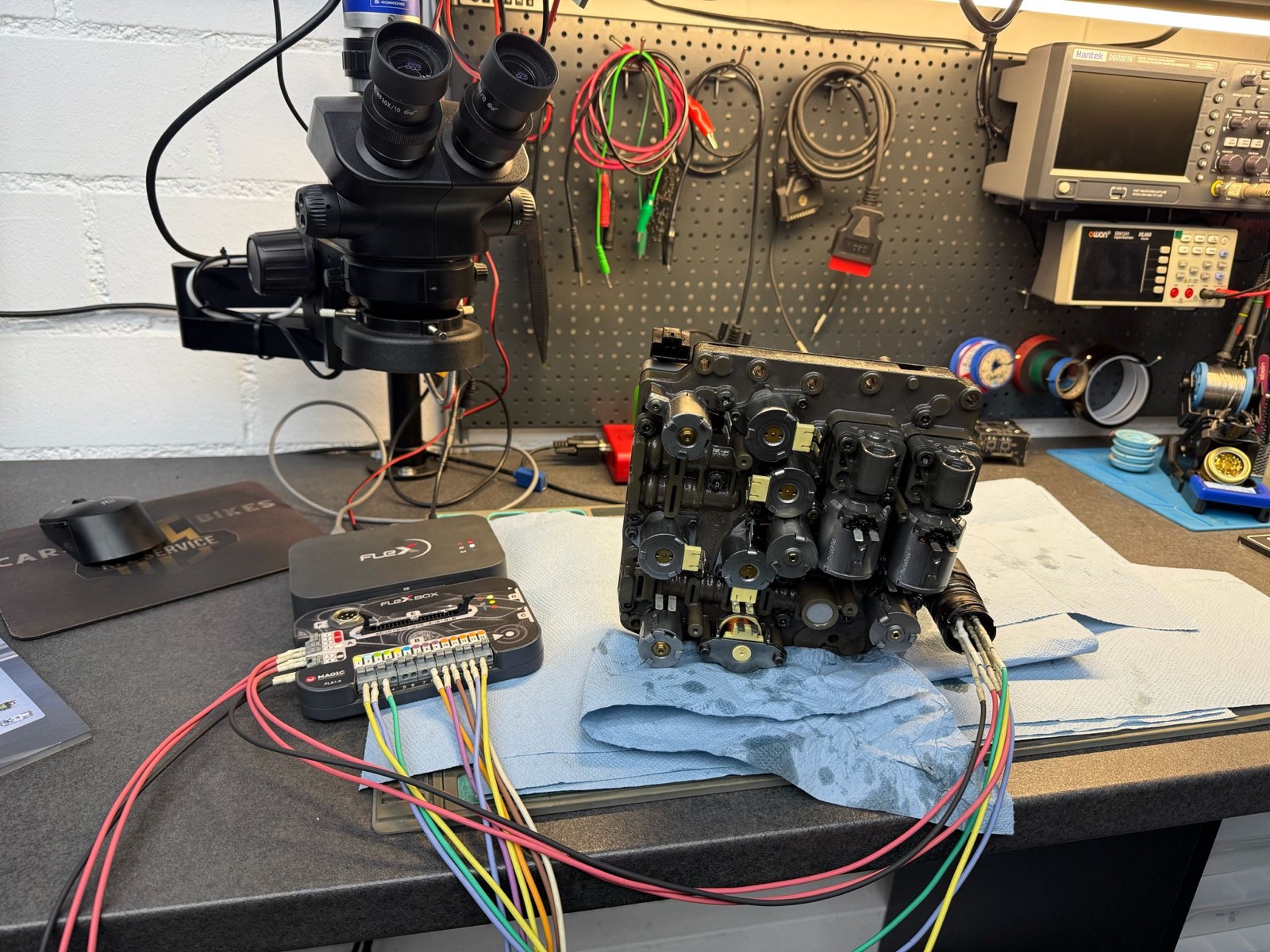 Getriebesteuergerät mit Hydraulikblock unter dem Mikroskop, angeschlossen an ein Programmiergerät